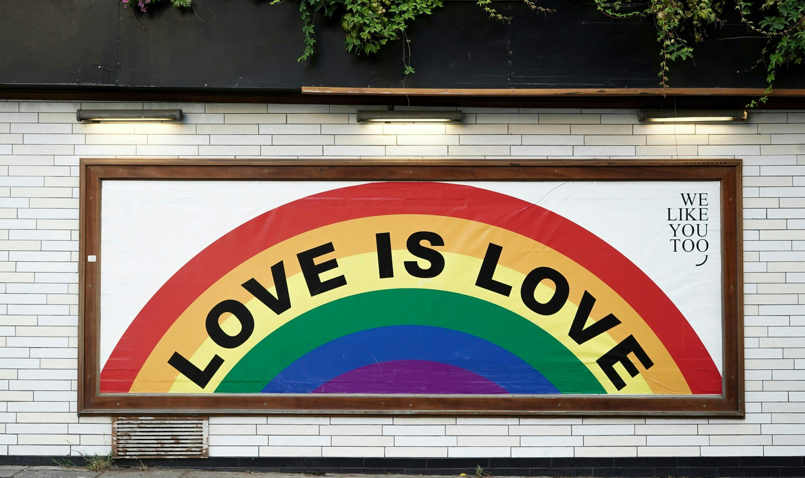 A billboard with a rainbow and the text "Love is love"