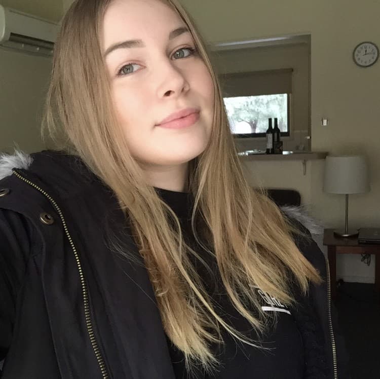 Kaitlyn in a home environment. She wears a black jacket.
