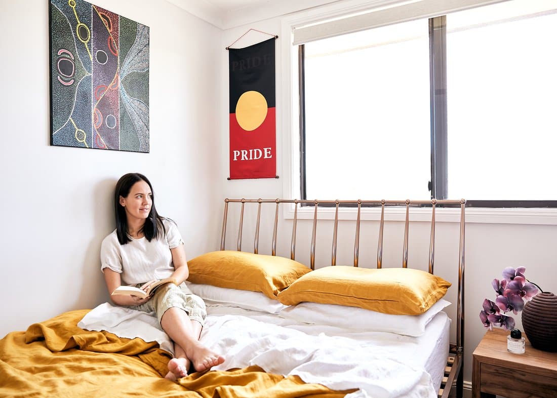 Marlee Silva in her bedroom. There is an Aboriginal flag hanging on the wall.