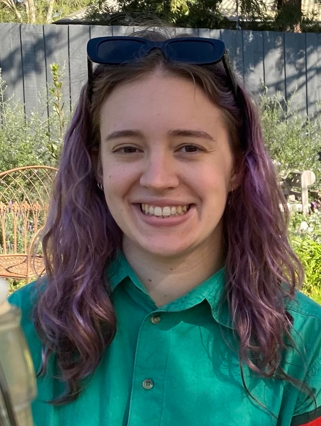 Alexandra Collins in a green shirt, smiling at the camera.