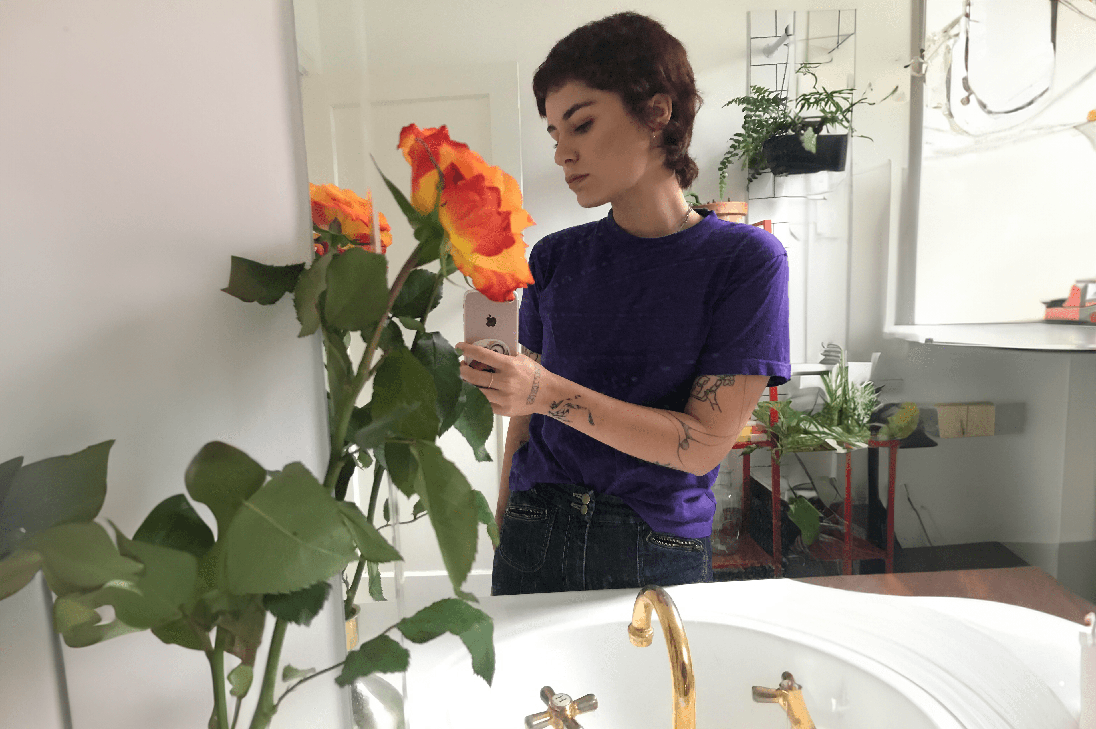 A mirror selfie of Madison Griffiths in her bathroom with flowers.