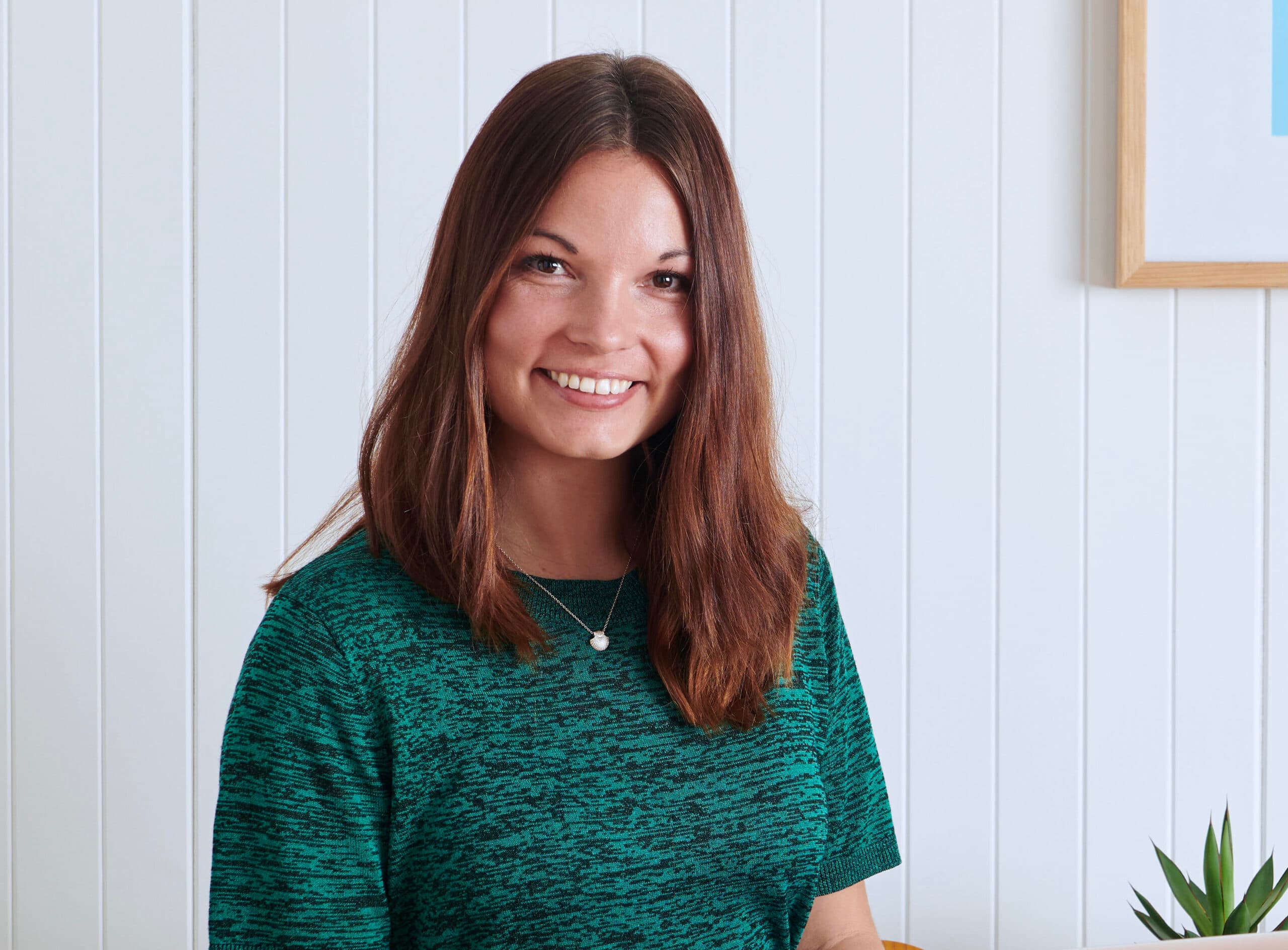 A headshot of Miranda Luby against a white wall.